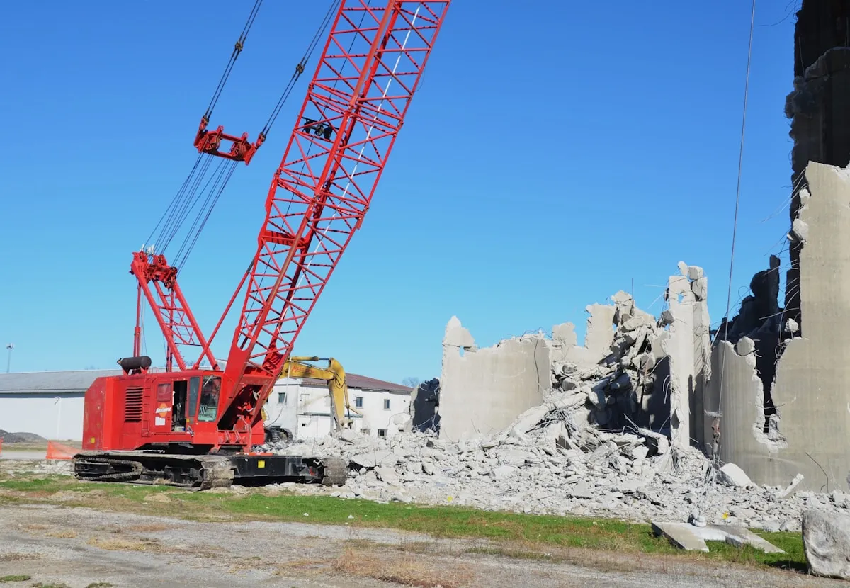 Building demolition with crane and excavator