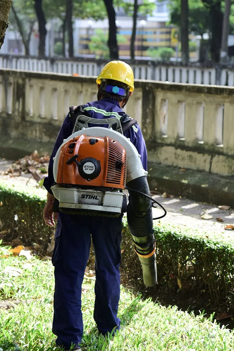 Worker using backpack leaf blower