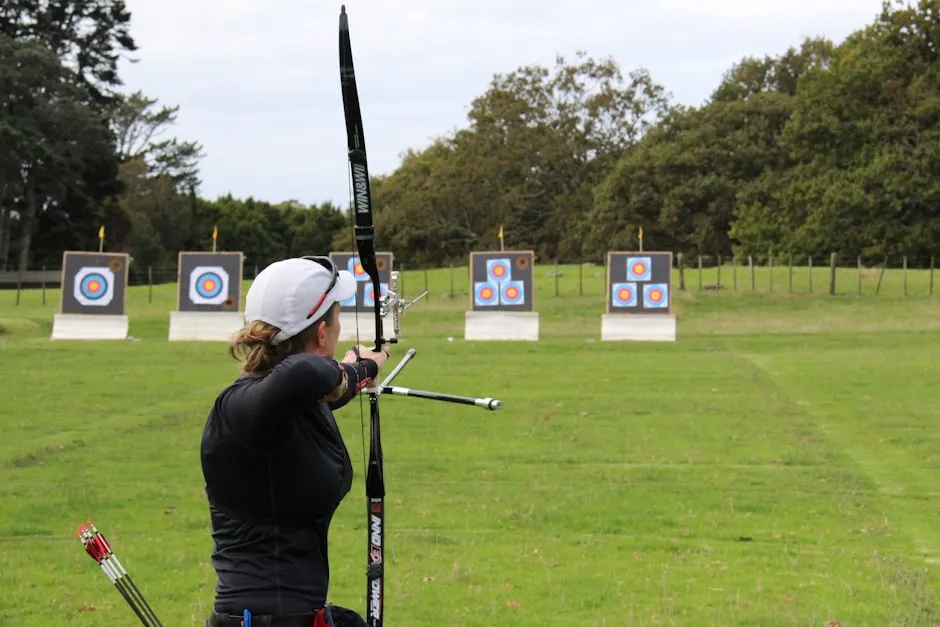 Archer drawing bow on range