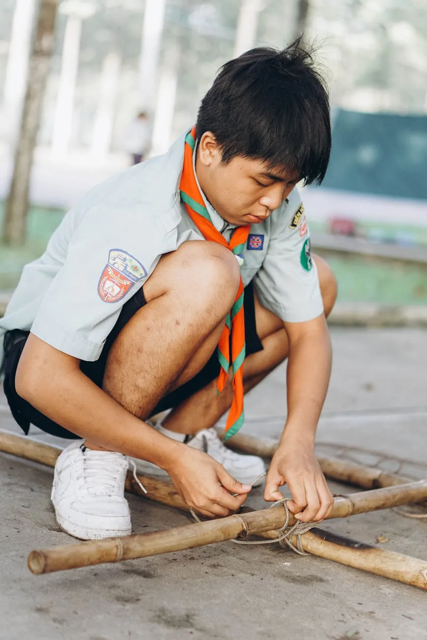 Scout tying knots on bamboo structure