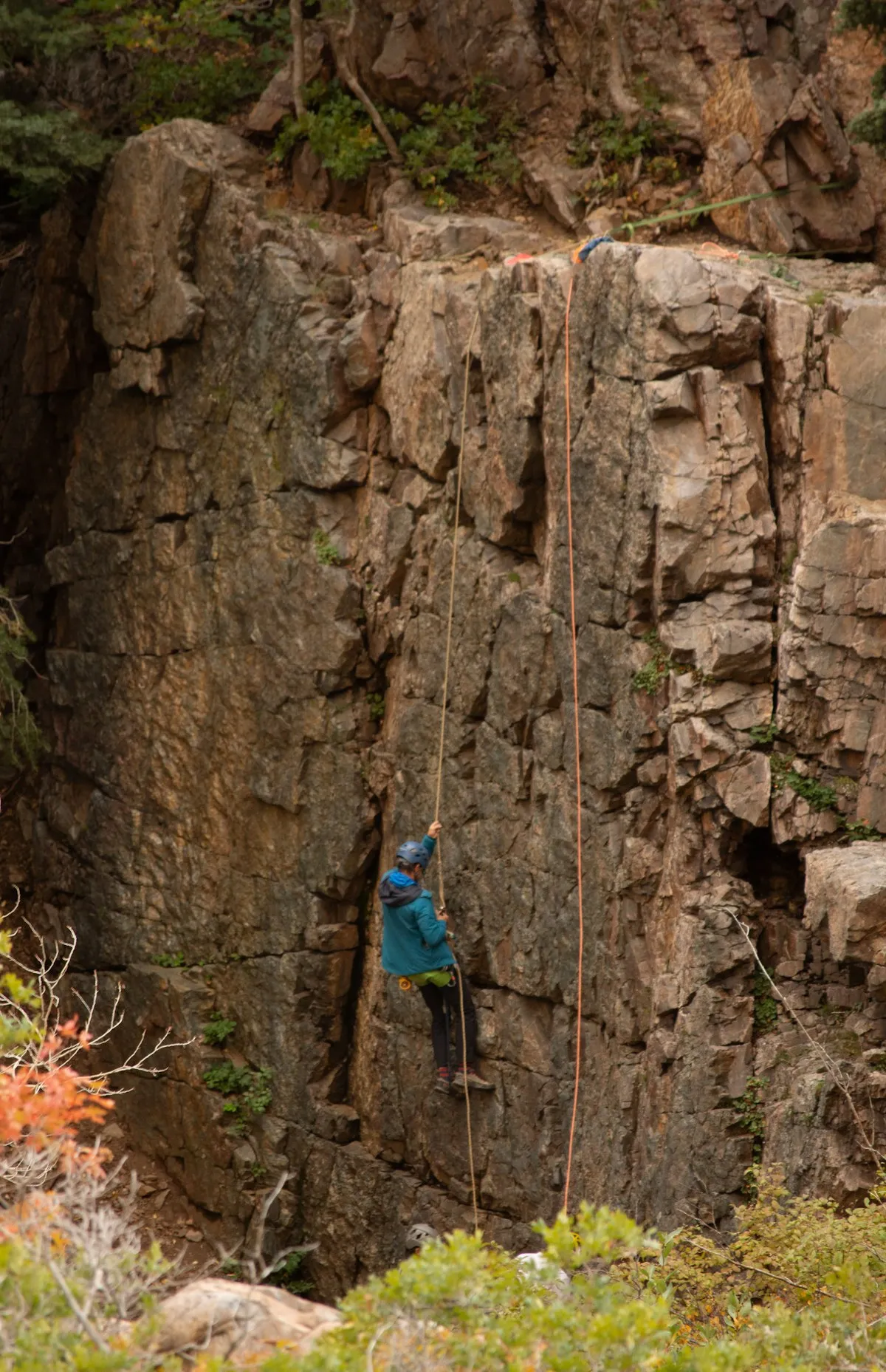 Rock climber ascending outdoor cliff face